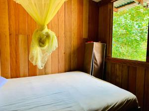uma cama num quarto de madeira com uma janela em FlowMove Algodoal em Algodoal