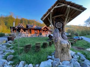 eine Uhr auf einem Baumstumpf vor einem Haus in der Unterkunft Koliba u Rytiera in Zvolen