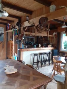 uma cozinha com mesa e bar com bancos de bar em Au petit coin western em Le Hohwald