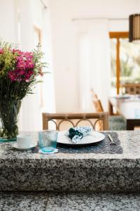 una mesa con un plato de comida y un jarrón de flores en Ocean View Villa/Luxury Puerto Bahia Resort/Samaná en Santa Bárbara de Samaná