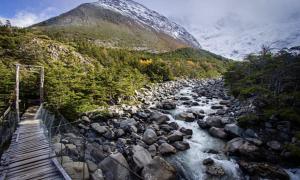普孔Pucon, la Capital del Sur de Chile的一座河上的桥梁,山底下