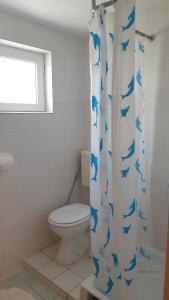 a bathroom with a toilet and a shower curtain with blue dolphins at Oaza in Ražanac +21 photos