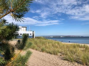 einen Strand mit einem weißen Gebäude darüber in der Unterkunft Strandapartment Kapitän Prora Binz in Binz