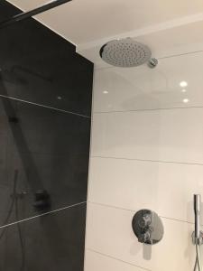 ein Bad mit einer Dusche und einer Decke in der Unterkunft Strandapartment Kapitän Prora Binz in Binz + 27 Fotos