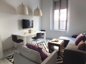 sala de estar con sofá y mesa con sillas en Apartamento Sevilla Alhondiga en Sevilla