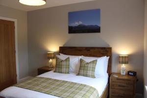 a bedroom with a bed with two night stands and two lamps at Stag Lodge in Spean Bridge