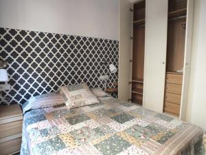 1 dormitorio con 1 cama con cabecero estampado en Apartamento Sevilla Alhondiga en Sevilla