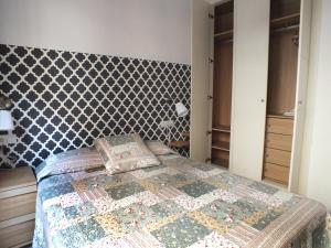 sypialnia z łóżkiem ze wzorzystym zagłówkiem w obiekcie Apartamento Sevilla Alhondiga w Sewilli