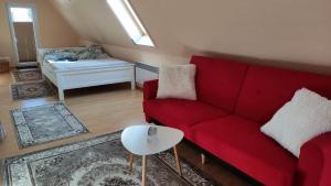 a living room with a red couch and a table at Lootsi puhkemaja in Kuressaare