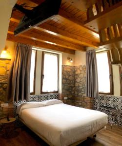 a bedroom with a large bed in a room with windows at Hotel Gastronómico Torre de Galizano in Galizano