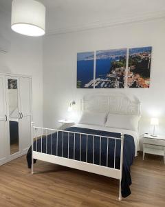 un letto bianco in una camera bianca con due tavoli di B&B Acqua Azzurra a Castellammare di Stabia