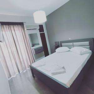 um quarto com uma cama grande e lençóis brancos em VASO'S APARTMENTS em Tolo