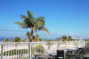 瓜魯雅的住宿－Curvão Surf House，海滩上的棕榈树,配有桌椅