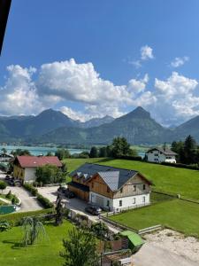 a view of a farm with mountains in the background at CHICLIVING Appartements in St. Wolfgang