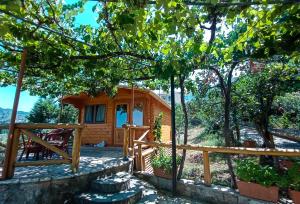 Cabaña de madera con porche y valla en Linda House Corfu, en Gastouri