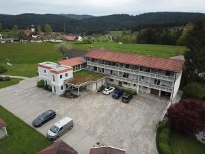 an aerial view of a building with cars parked in a parking lot at Pension Waldblick in Böbrach