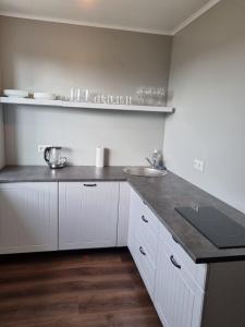a kitchen with white cabinets and a counter top at Soelaane 12 Apartment2 in MikitamÃ¤e