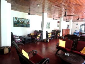 a waiting room with chairs and tables in a building at Star Holiday Resort in Hikkaduwa