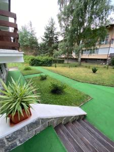 un jardín con césped verde y un banco de madera en Apartmán Slapy-Ždáň en Slapy