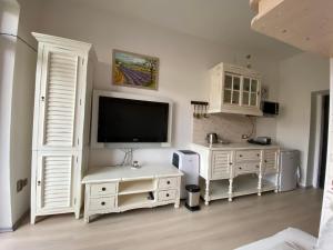 una camera da letto con mobili bianchi e TV a schermo piatto di Apartmán Slapy-Ždáň a Slapy
