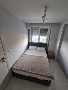 un piccolo letto in una camera con finestra di Alilomis Lux Apartments a Paralia Katerinis