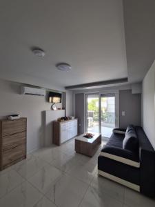 un soggiorno con divano e tavolo di Alilomis Lux Apartments a Paralia Katerinis