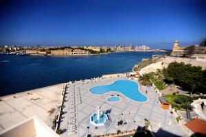 an aerial view of a swimming pool next to the water at Grand Hotel Excelsior in Valletta