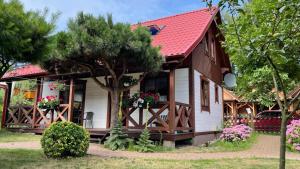 a house with a red roof and a tree at NAJBLIŻEJ MORZA DOM CAŁOROCZNY Jastarnia in Jastarnia