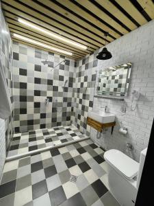 uma casa de banho com piso em xadrez preto e branco em Gabala Boutique Hotel em Gabala