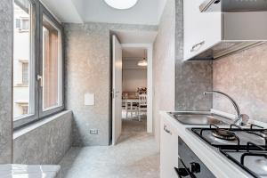 een keuken met een wastafel en een fornuis bij CRYSTAL TREVI FOUNTAIN - romedreamhome in Rome