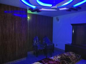 um quarto com luzes azuis e uma mesa e cadeiras em Full Private House Floor with Lounge & Balcony - Townhouse - Homestay em Lahore