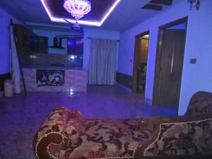 uma sala de estar com um sofá e um lustre em Full Private House Floor with Lounge & Balcony - Townhouse - Homestay em Lahore