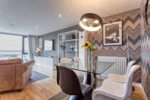 a dining room with a glass table and chairs at SECC Hydro Executive 7 Apartment in Glasgow