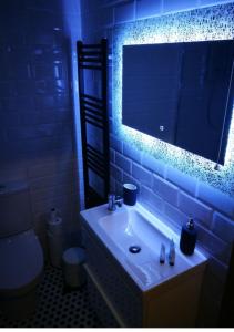 La salle de bains est pourvue d'un lavabo, d'un miroir et de toilettes. dans l'établissement Bluebell Cottage - with hottub, à Newry