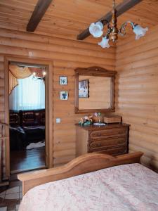 a bedroom with a bed and a dresser and a mirror at Sadyba Pochayiv in Pochayiv