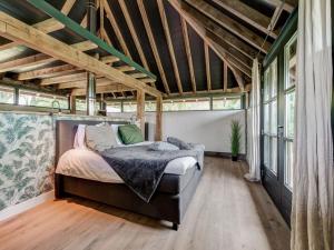 1 dormitorio con 1 cama en una habitación con ventanas en Lush holiday home with a private Hot Tub en Zeeland