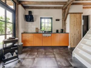cocina grande con armarios de color naranja y fregadero en Lush holiday home with a private Hot Tub, en Zelanda