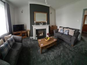 a living room with two couches and a fireplace at 1 Grange Street in Pelton
