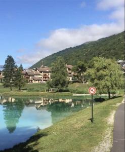 a no swimming sign next to a body of water at Très bel appartement face au lac de Bozel in Bozel