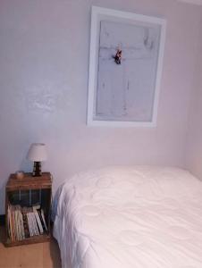 a bedroom with a bed and a picture on the wall at Très bel appartement face au lac de Bozel in Bozel