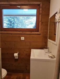 a bathroom with a sink and a window at Très bel appartement face au lac de Bozel in Bozel