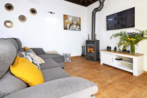 a living room with a gray couch and a tv at Casa Pino Arujo in Tijarafe