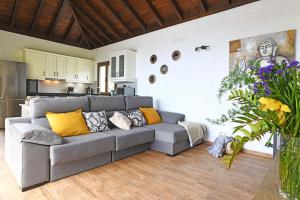 a living room with a gray couch and yellow pillows at Casa Pino Arujo in Tijarafe