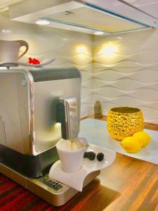 a coffee maker on a table with a cup of coffee at Istrian stone house in the heart of the beautiful fishing village Fažana - only few steps from the sea and the wonderful beach - incl PLASMA-QUAD-PLUS-FILTER against C o v i d in Fažana