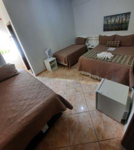 a room with two beds and a couch in it at Pousada Guinda DIAMANTINA -MG in Diamantina