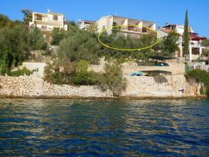 une maison sur une colline à côté d'une masse d'eau dans l'établissement Apartment Ivan - 15m from beach, à Vinišće