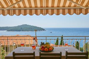 a table with a bowl of fruit and wine glasses at Sea & the City in Dubrovnik