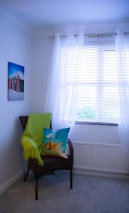 uma cadeira sentada num quarto com uma janela em Stunning Seafront House with garden and private parking em Eastbourne