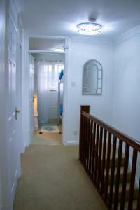 un pasillo con una escalera que conduce a una habitación en Stunning Seafront House with garden and private parking en Eastbourne