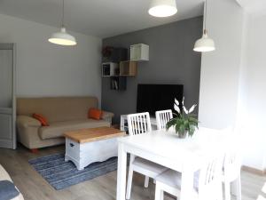 een woonkamer met een witte tafel en een bank bij Bassiero Apartament in Esterri d'Àneu